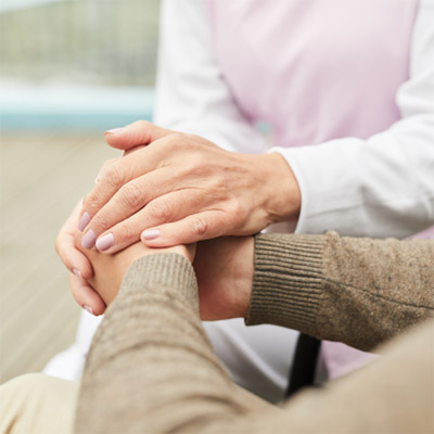 caregiver supporting patient holding hands